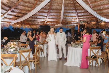 Guests at round tables under the draped pavilion ceiling during a reception